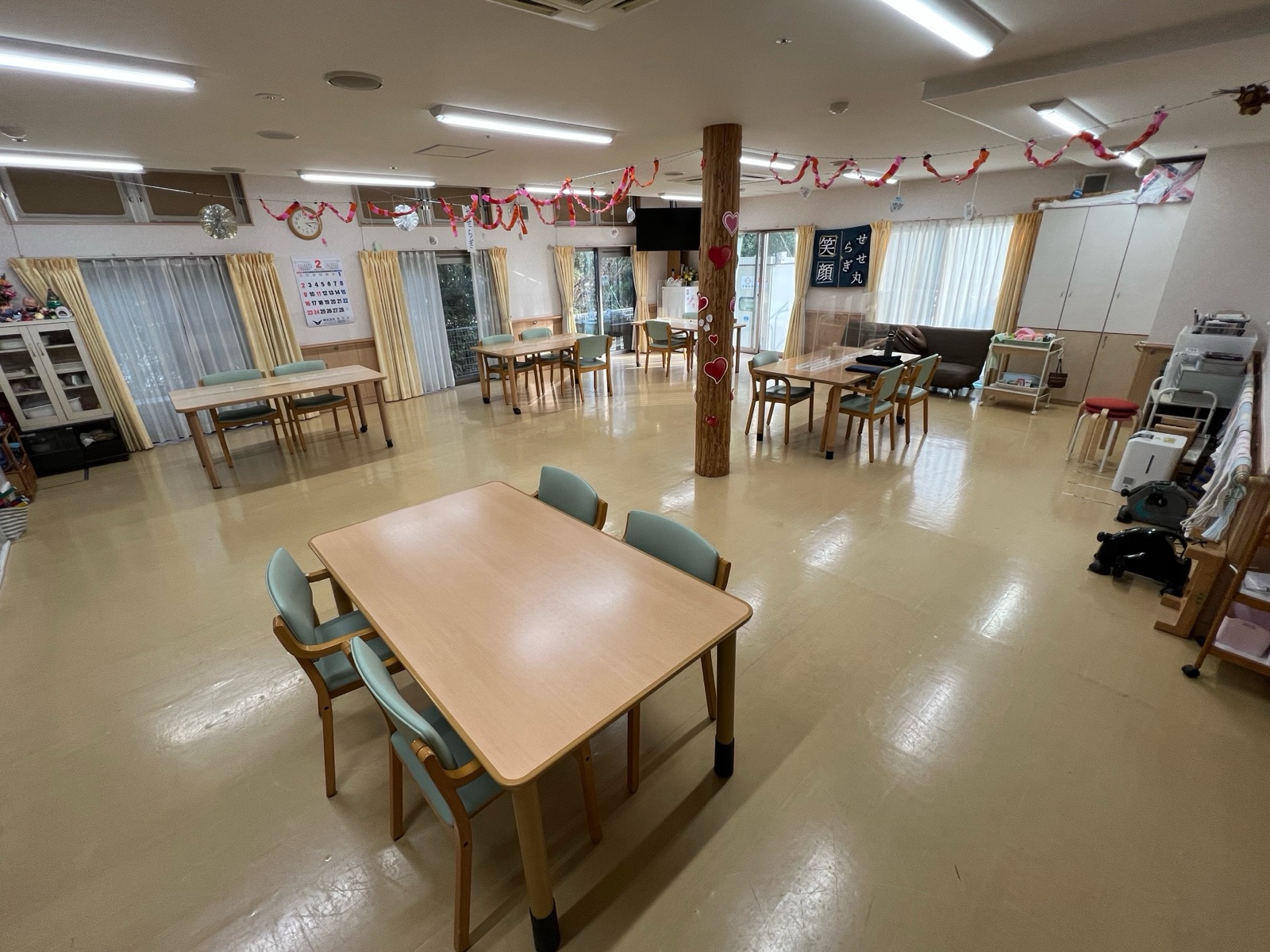 テーブルが並ぶデイサービスのフロア