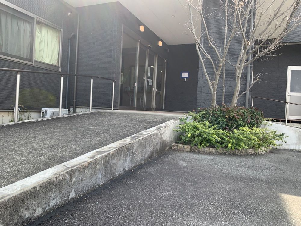 玄関へ続くゆるやかなスロープと植え込み