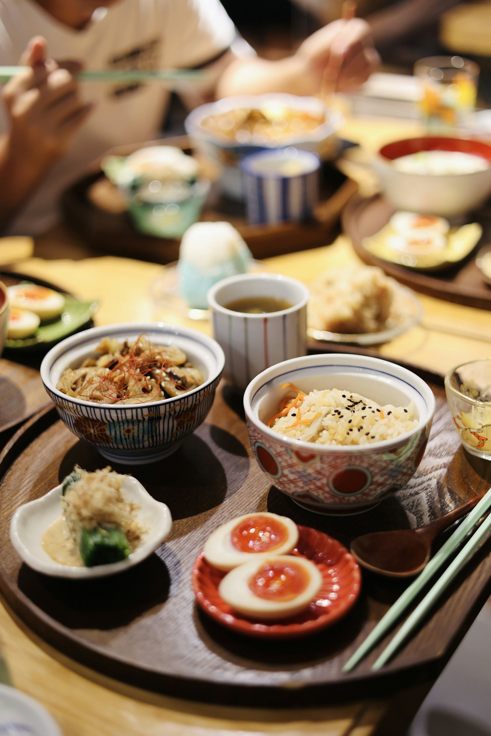 炊き込みご飯、きのこの炒め物、味付け卵、小鉢が並ぶ食卓