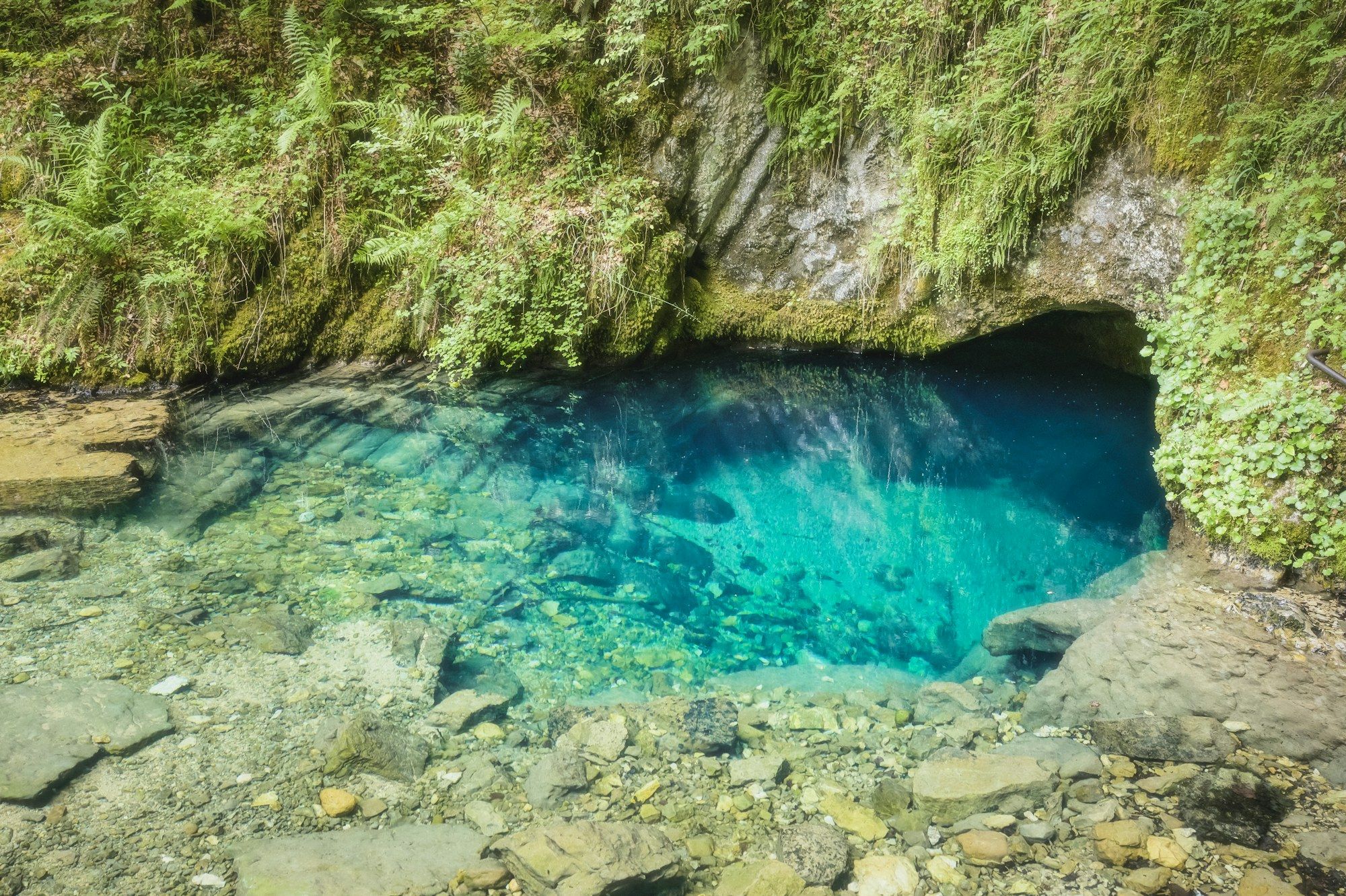 岩の間から湧き出る、澄んだ青い泉