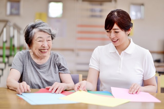色紙を前に、職員と笑い合う高齢の女性